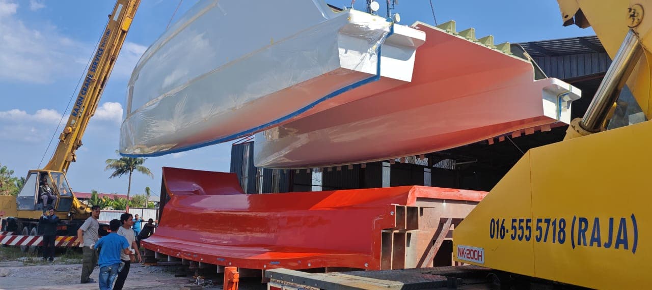 A Candice-built catamaran hull on the trailer, mold being craned overhead at the yard