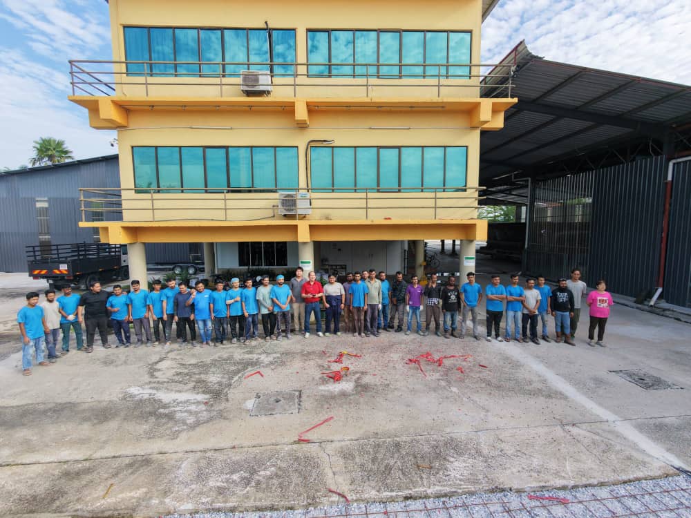 Aerial photo of the full Candice Yacht crew in front of the yard building